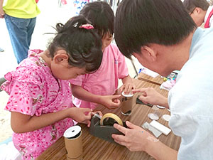 作品づくりに取り組む子どもと指導する学生