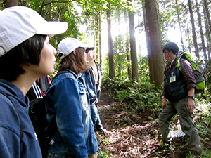 セラピーガイドの話を聞く学生達（智頭町天木にて）